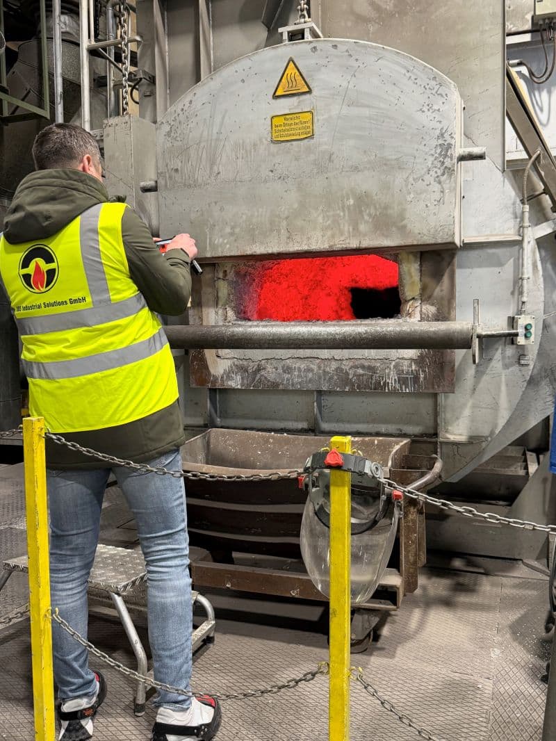 Detailaufnahme einer verschlissenen Feuerfestauskleidung in einem Aluminiumofen mit sichtbaren Rissen und Schlackenanhaftungen